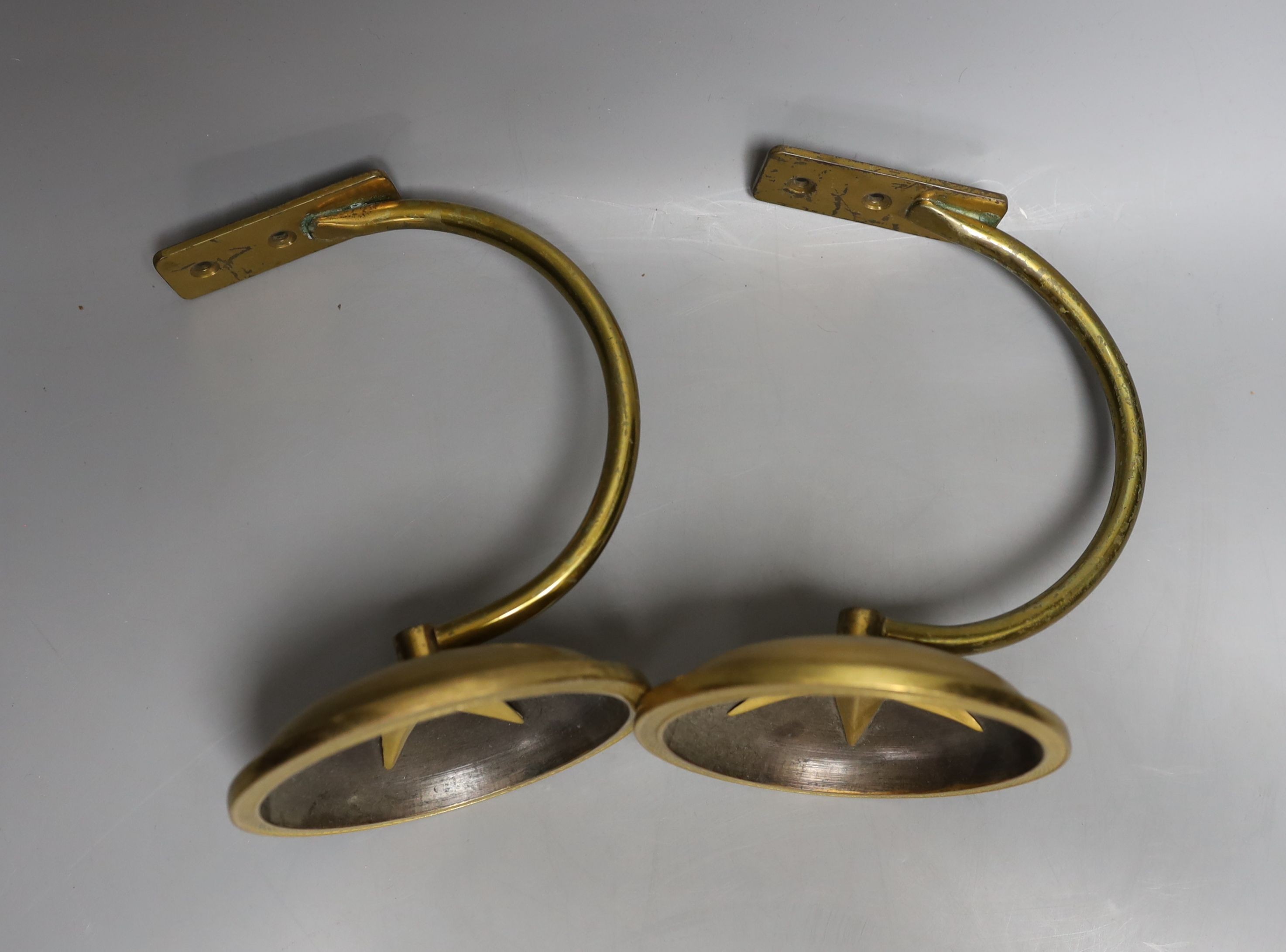 A pair of gilt metal curtain tie-backs and two other similar tiebacks